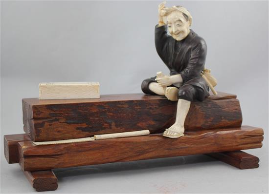 A Japanese ivory, bronze and wood okimono of a carpenter, early 20th century, 32.5cm., some losses